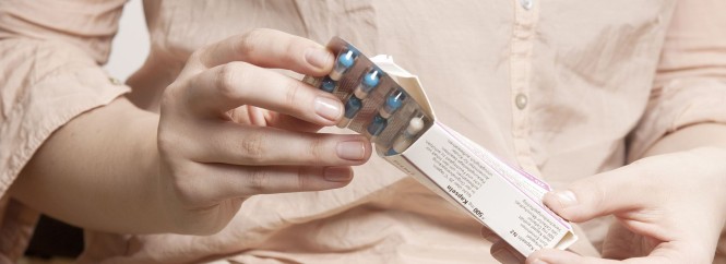 Eine Frau öffnet eine Arzneimittelpackung