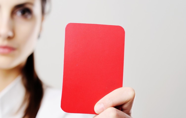 Eine Frau hält eine rote Karte hoch
