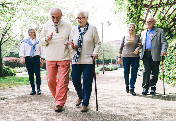 Ältere Menschen mi Migrationshintergrund gehen im Park spazieren