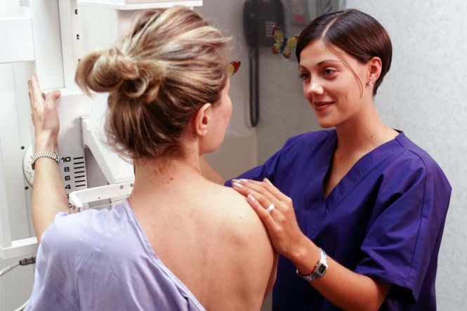 Eine Krankenschwester assistiert einer Frau bei einer Röntgenuntersuchung