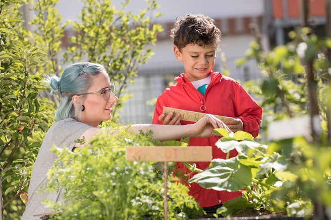 Eine Frau und ein Junge arbeiten in einem Gemüsegarten