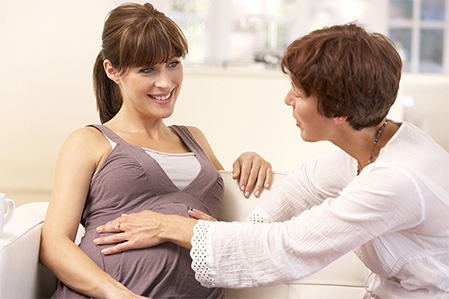 Eine Hebamme kümmert sich um eine Schwangere