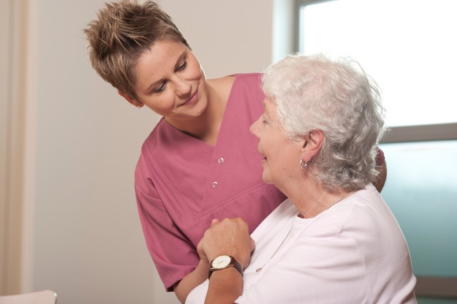 Eine Pflegerin unterhält sich mit einer älteren Frau